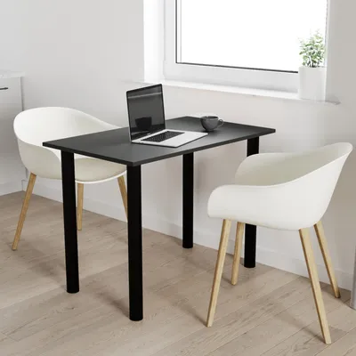 A small black table with two white chairs in a room with a window.