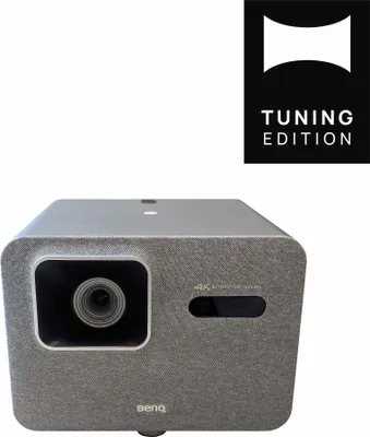 A product shot of a BenQ projector with a marketing logo in the top right corner.