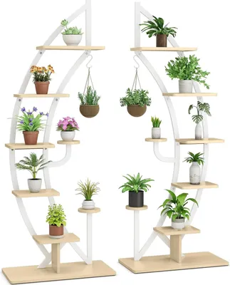 Two white, curved plant stands with wooden shelves, each holding multiple potted plants.