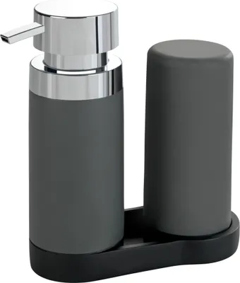 A soap dispenser and a cup on a tray.