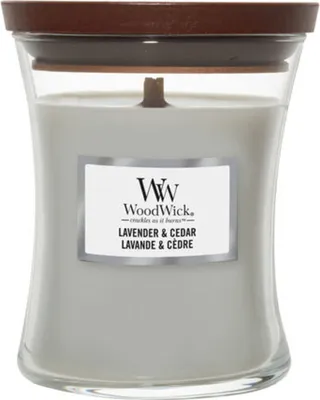 A WoodWick Lavender & Cedar scented candle in a clear glass jar with a wooden lid.