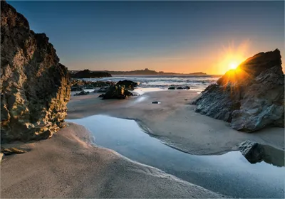 Produktbild von Wallario selbstklebendes Poster - Sonnenuntergang hinter einem Felsen am Strand, Größe: 70 x 100 cm