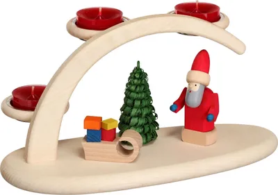 Ein Holzlichterbogen aus dem Erzgebirge zeigt einen Weihnachtsmann mit einem Geschenkschlitten und einem grünen Spanbaum und bietet Platz für drei rote Teelichter.