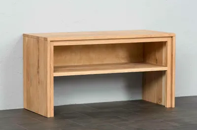 A wooden bench with two shelves against a white wall.