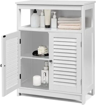 A white bathroom cabinet with two louvered doors, one open, displaying various toiletries and folded towels on its shelves.