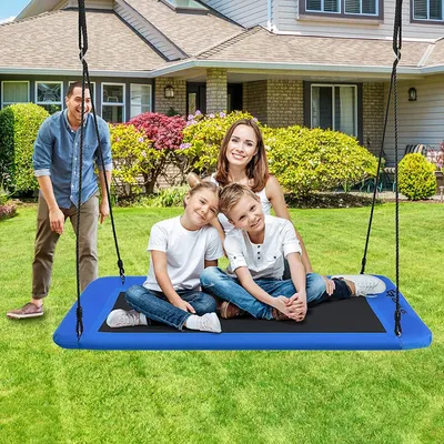 A family is enjoying a swing set in their backyard.