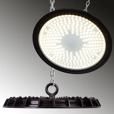 A circular LED light fixture is suspended by chains against a gradient gray background.