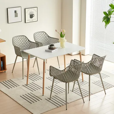 A dining set with a white table and four gray chairs arranged on a rug in a well-lit room.