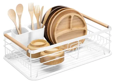 A white metal dish rack filled with wooden plates, bowls, and utensils.