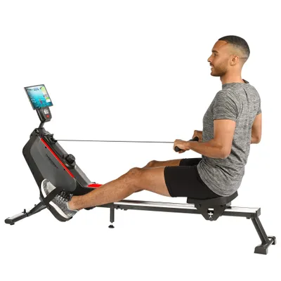 A man is using a rowing machine.