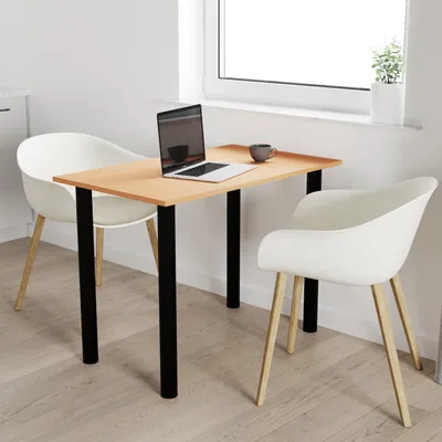 A small wooden table with black legs, set up in a bright room with a window. Two white chairs are placed on either side of the table, and a laptop and a coffee cup are on the table.