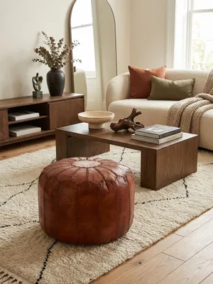 Runder Leder Pouf in Braun von oben gesehen, platziert auf einem texturierten Teppich als stilvolles Accessoire im Wohnbereich._#sku_SAFWL6.088#