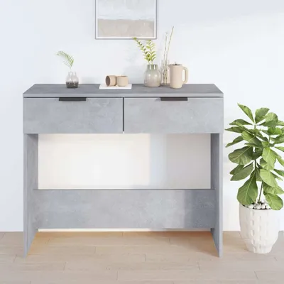A console table with drawers and a shelf, decorated with a plant and some decorative items.