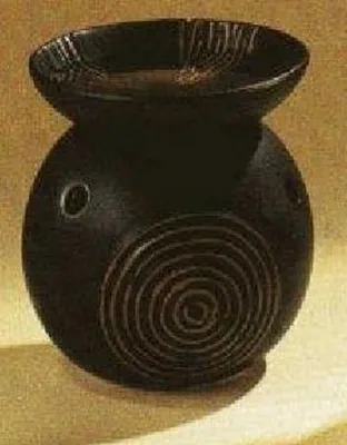 Eine schwarze, runde Duftlampe mit einem konzentrischem Kreis-Muster.