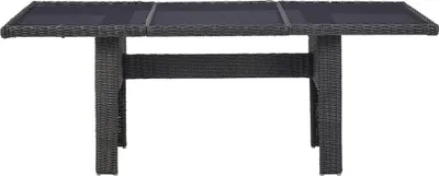 A dark gray wicker dining table with a glass top, shown from the front on a white background.