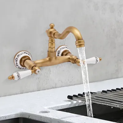 A wall-mounted faucet with water running into a sink.