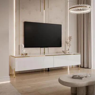 A modern white TV stand with gold accents is shown in a well-lit living room setting.