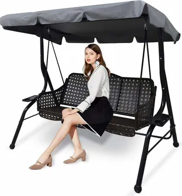 A woman sits on a garden swing chair.