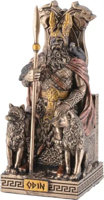 A statue of the Germanic god Odin sitting on his throne, flanked by two wolves and with a raven on his shoulder. The base of the statue has the word 'ODIN' inscribed on it.