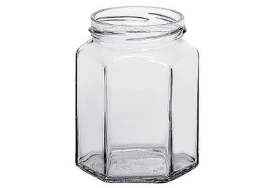 A clear, studio shot of an empty, hexagonal glass jar against a white background.