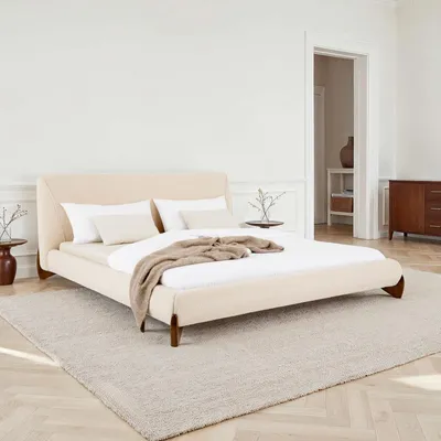 A bedroom scene with a bed, nightstands, and dresser.