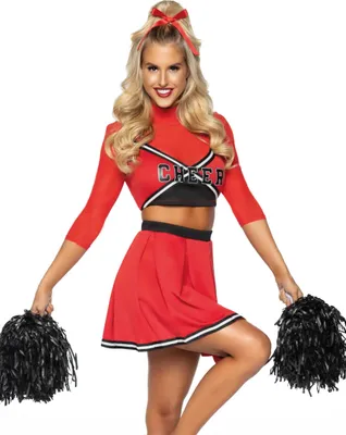 A woman dressed as a cheerleader poses with pom-poms.