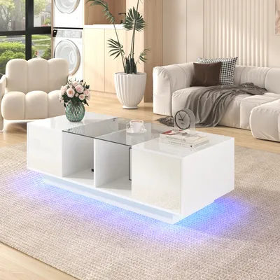 A modern living room with a white couch, a plush armchair, and a white coffee table with LED lighting.