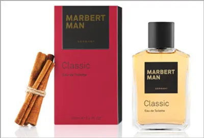 A product shot of Marbert Man Classic Eau de Toilette, including the perfume bottle, its packaging, and cinnamon sticks.