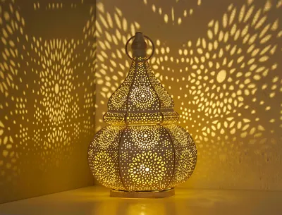 A decorative lantern casting intricate shadows on a wall.