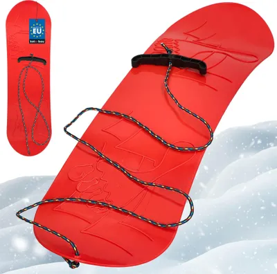 A red plastic snowboard for children with a rope and handle, shown on a snowy background.