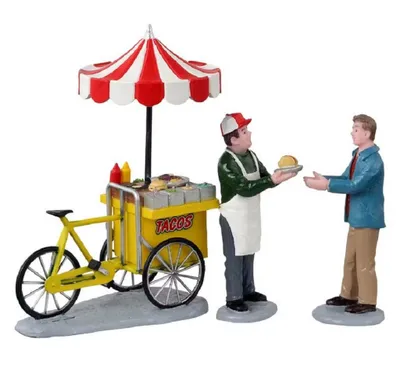 Miniatur-Szene eines Taco-Wagens, der von Verkäufer bedient wird, der einem Kunden einen Taco reicht