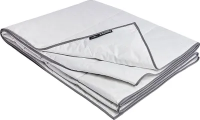 A folded white blanket with gray trim, lying on a white surface.