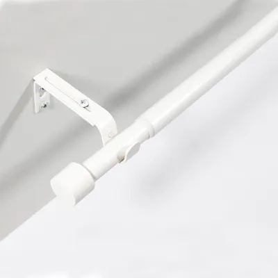 A white adjustable curtain rod mounted on a wall.