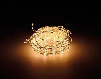 A coiled string of warm white LED lights on a dark background.