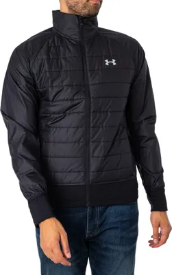 A man wearing a black Under Armour jacket and blue jeans.