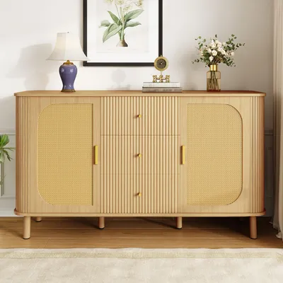 A modern wooden sideboard with rattan doors and gold handles, displayed in a well-lit room with a painting and a vase of flowers on top.