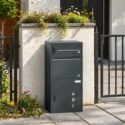 SoBuy Paketbox OGS66-DG als dunkelgrauer Metallschrank vor Hauswand mit Blumen und Gitterzaun