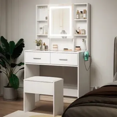 A white vanity table with a lighted mirror and a stool, set in a bedroom.