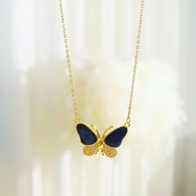 Goldkette mit Schmetterlingsanhänger, mit dunkelblauen Emailleflügeln und mit Pavé besetzten klaren Steinen an den unteren Flügeln