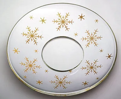 Produktbild von Glas-Kerzenmanschette - Tropfenfänger für Kerzen bis Ø 25 mm. Der Außendurchmesser der Kerzenmanschette beträgt Ø 70 mm. Hergestellt in Handarbeit aus klarem Glas. Das Ornament wird aus 21-karätigem Gold gefertigt. Schützt vor herablaufendem Wachs auf Ihrem gedeckten Tisch.