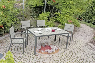 An outdoor patio setting with a table and chairs around a fire pit.