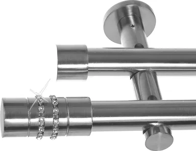 Close-up of a double curtain rod system with decorative elements.