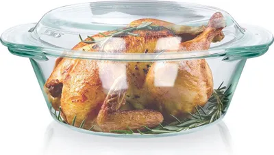 A roasted chicken with rosemary in a glass baking dish.