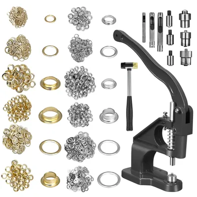 A collection of grommets and eyelets in various sizes and colors, along with a grommet setting tool and hammer, laid out on a white background.