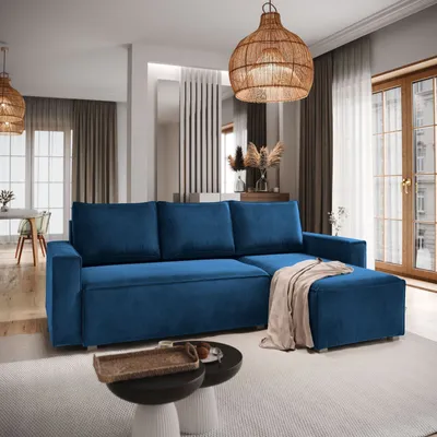A modern living room with a blue sectional sofa, ottoman, and coffee table.