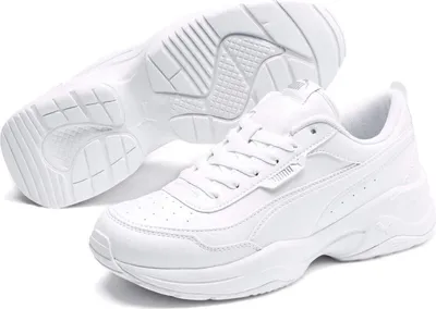 A pair of white Puma sneakers shown from a slightly elevated angle, with one shoe placed in front of the other, and the sole of one shoe visible.