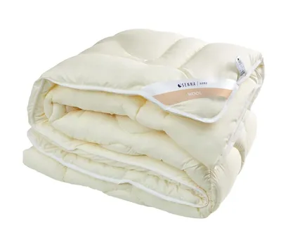 A folded ecru wool duvet on a white background.