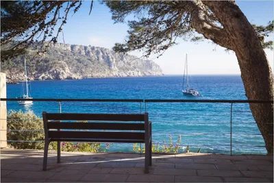 Produktbild von Wallario Poster - Einsame Bank am Meer - Spanien im Sommer, Kunstdruck Größe: 61 x 91,50 cm