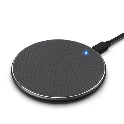 A black wireless charging pad with a blue indicator light and a connected black USB cable, shown on a white background.