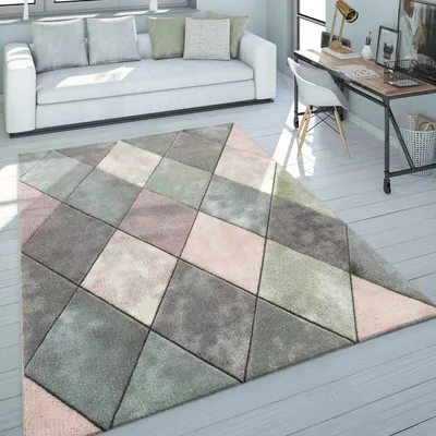 A living room with a white sofa and a geometric patterned rug.